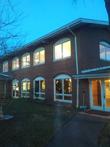 A brick building showcasing illuminated windows during the evening hours.