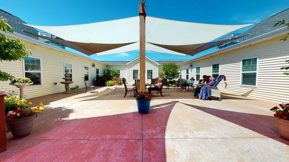 An inviting courtyard with sail shades and comfortable seating, perfect for relaxation on a sunny day.