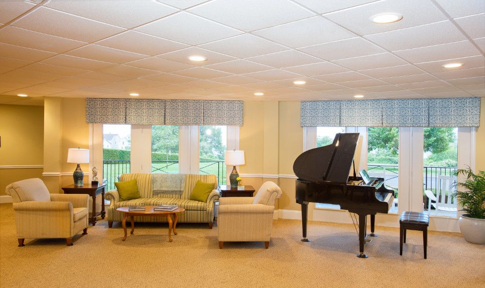 A cozy living room featuring a grand piano and comfortable seating arrangements.