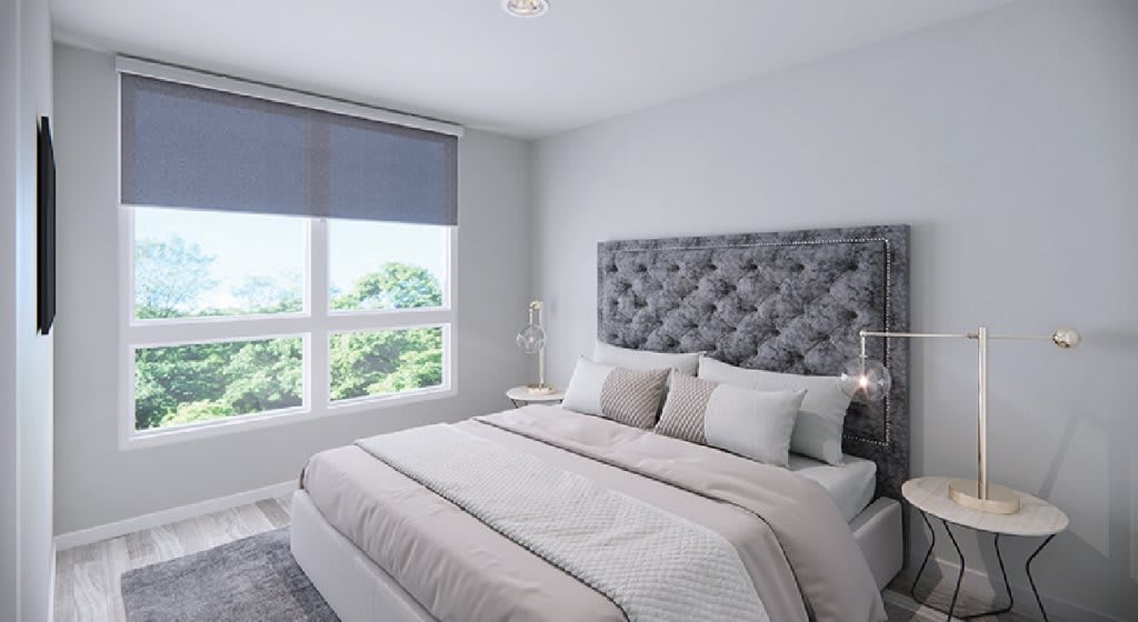 A modern, minimalist bedroom with a large bed and ample natural light.