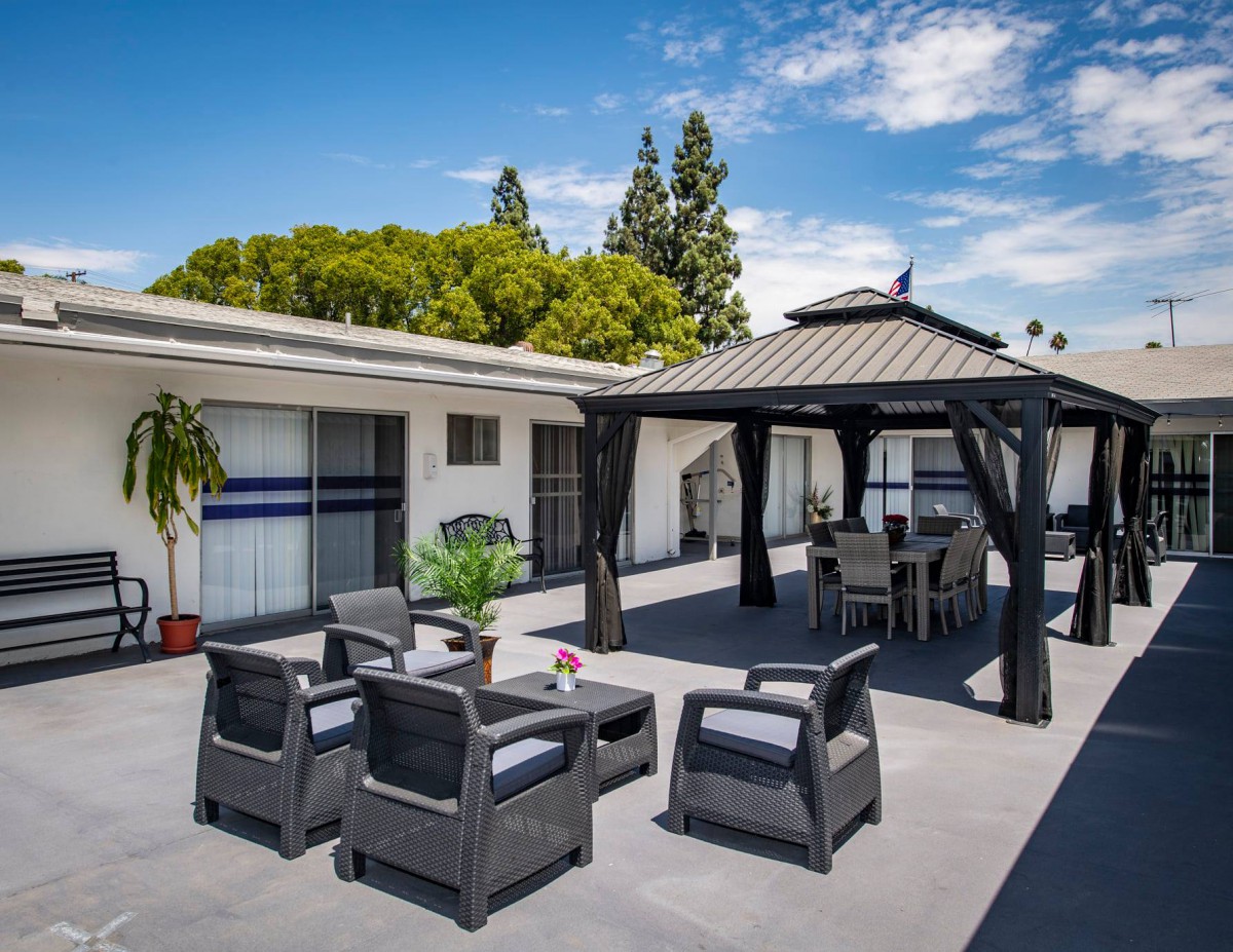 A spacious outdoor patio featuring comfortable seating and a gazebo, perfect for relaxation.