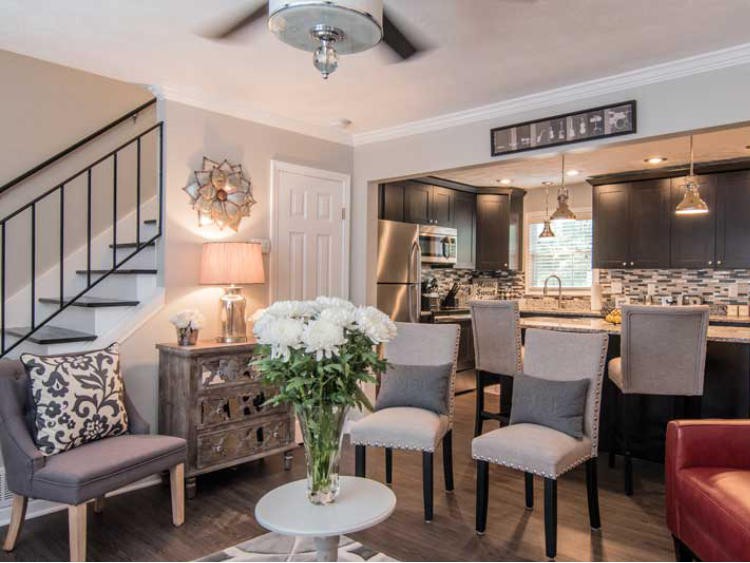 A modern living space with an open kitchen and dining area, elegantly decorated with neutral tones and stylish furniture.
