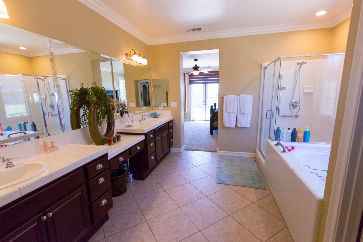 A spacious modern bathroom with a double vanity, large mirrors, and a bathtub.