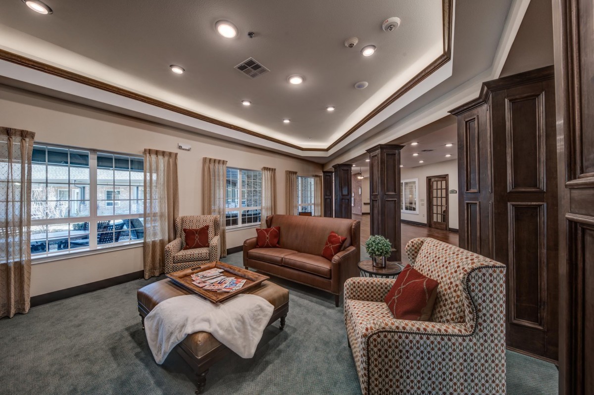 A cozy living room with sofas, armchairs, and a coffee table arranged under soft lighting.