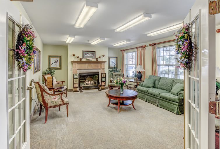 A cozy living room with a fireplace, green sofa, and comfortable seating.