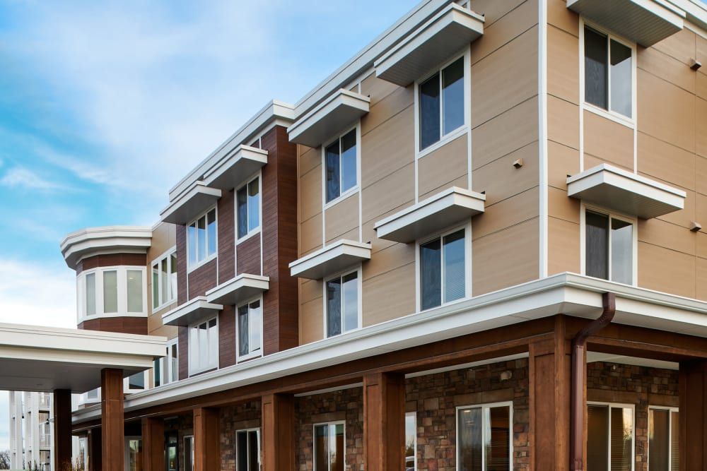 A modern apartment building with multiple stories and large windows.