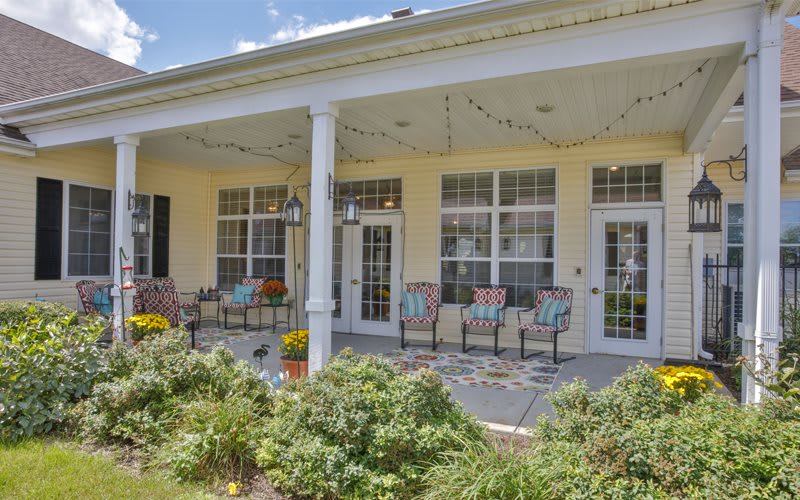 A cozy porch with chairs and plants, perfect for relaxing outdoors.