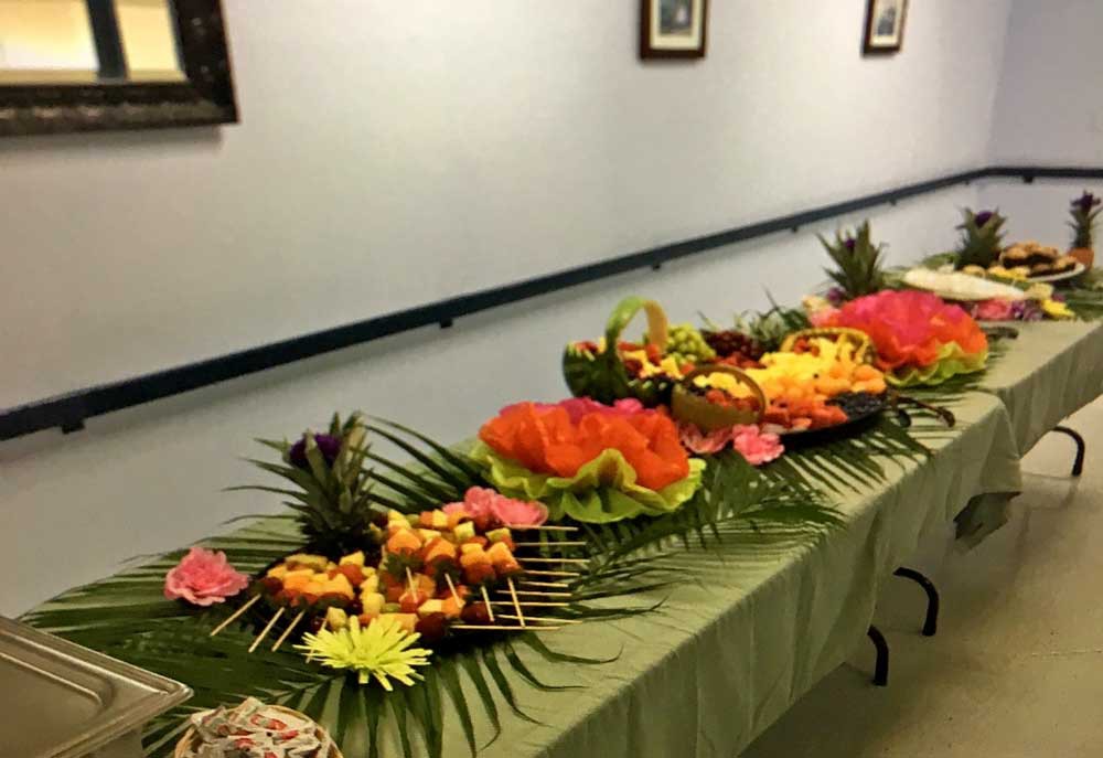 A beautifully arranged tropical-themed buffet with an assortment of fruits.