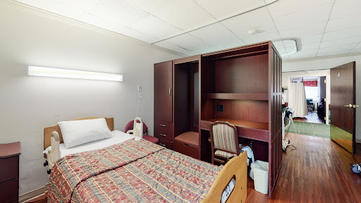 A well-furnished hospital room featuring a bed and storage space.