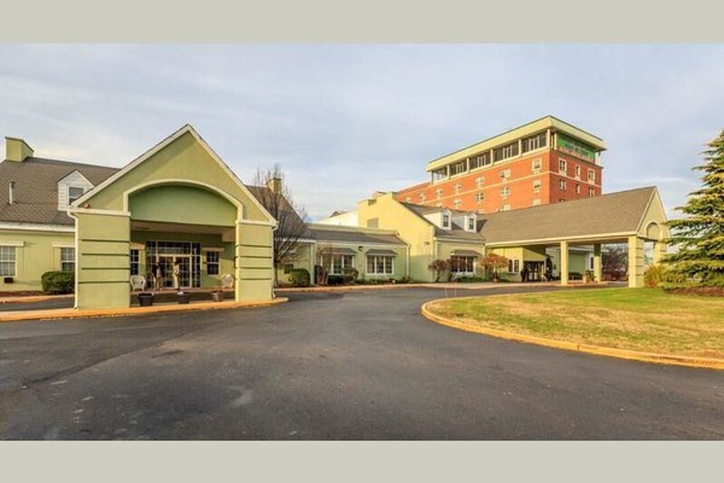 A building complex with a driveway and entrance, featuring both modern and traditional architectural elements.