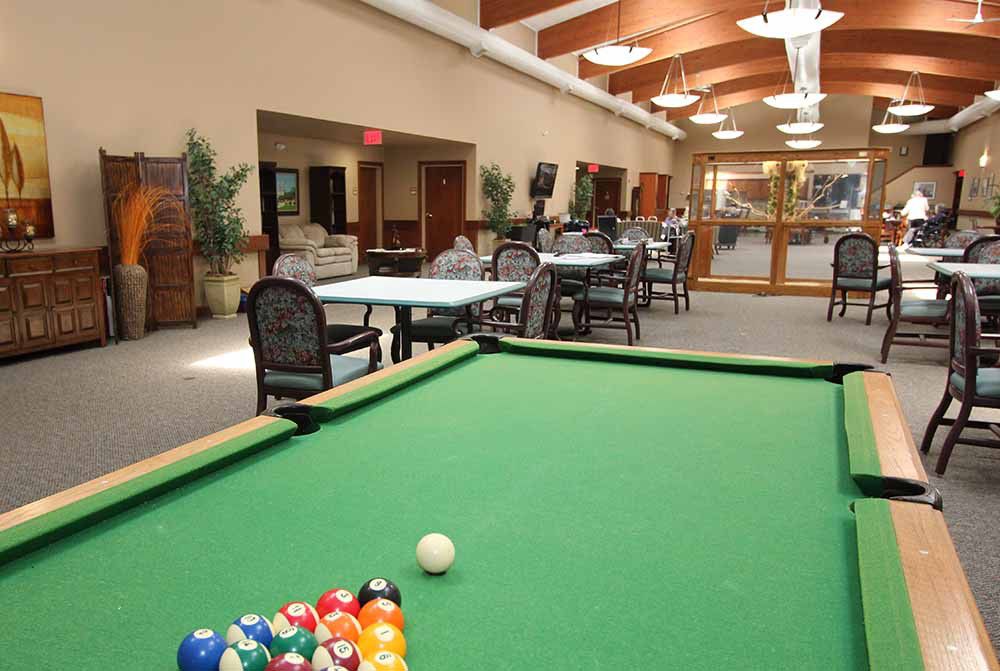 A recreational game room featuring a billiard table and seating area.