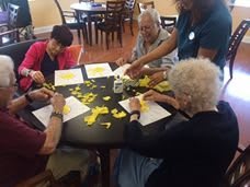 A group of seniors engaging in a crafting activity together at a table.