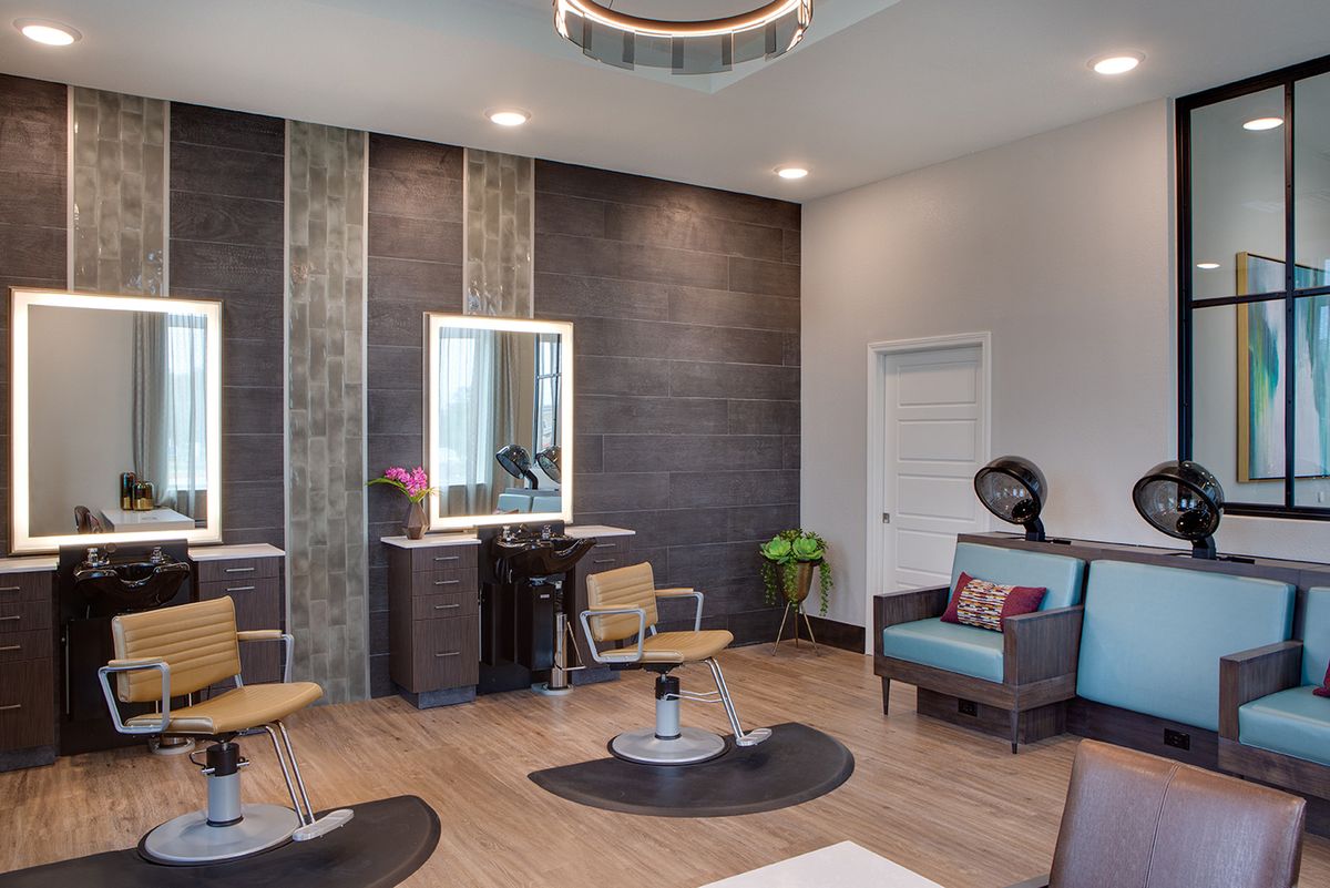 A modern hair salon interior featuring stylish seating and mirrors.