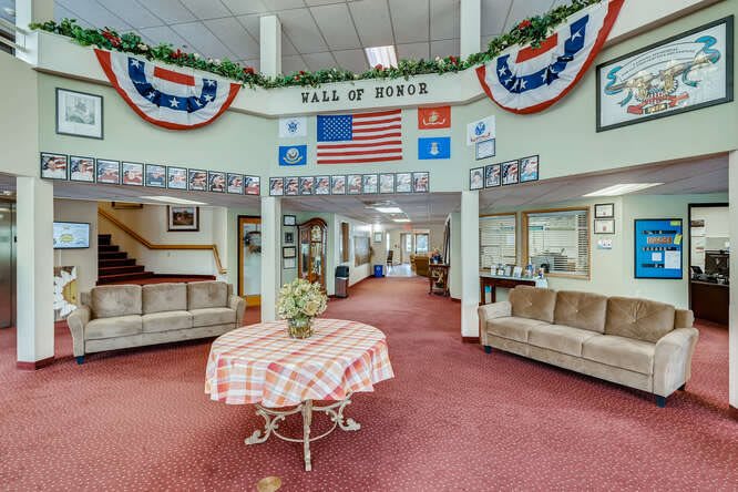 A decorated lobby area featuring a 'Hall of Honor' display with flags and banners.