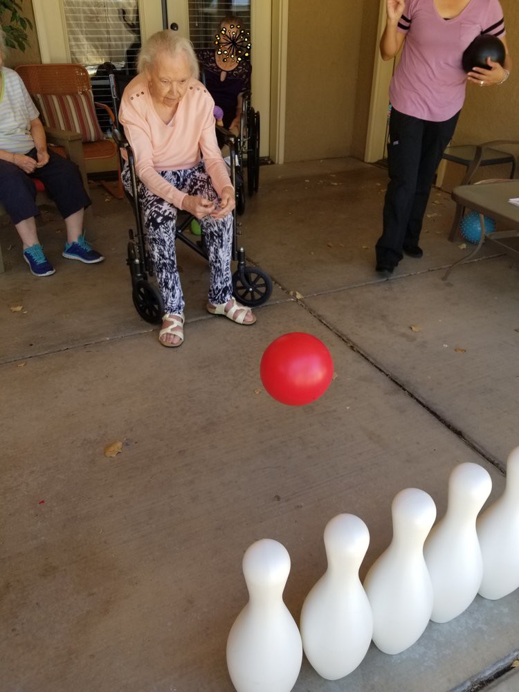 Indoor bowling game in progress with a red ball and plastic pins.