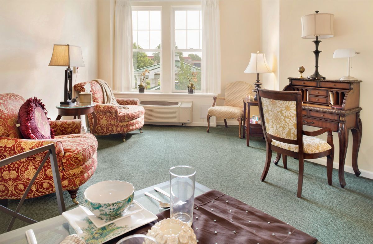 A cozy living room featuring elegant furniture and a large window letting in natural light.