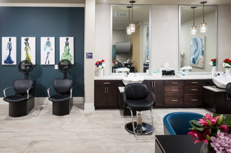 A modern hair salon interior with stylish chairs, large mirrors, and organized salon equipment.