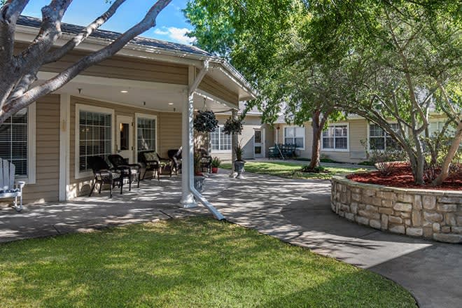 A serene outdoor patio area surrounded by trees and greenery.