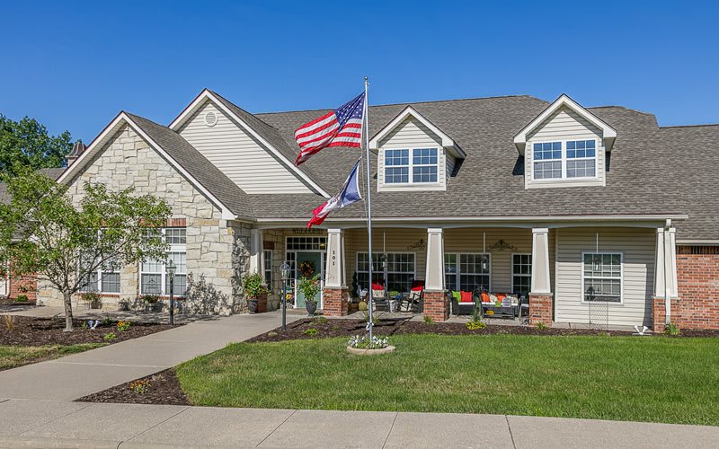 A residential house with American and Texas flags displayed outside.