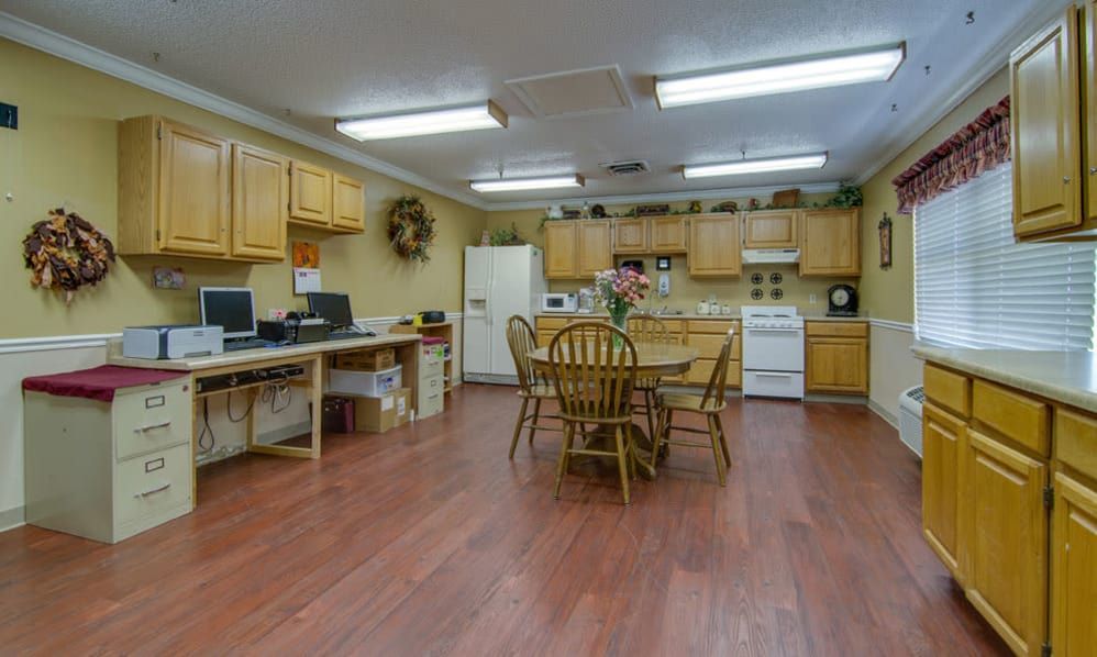 A cozy kitchen with wooden cabinets, a dining table, and standard appliances.