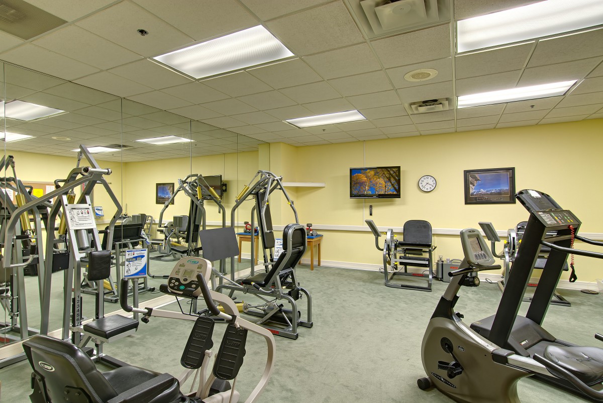 A well-equipped gym with various exercise machines and a clean interior.