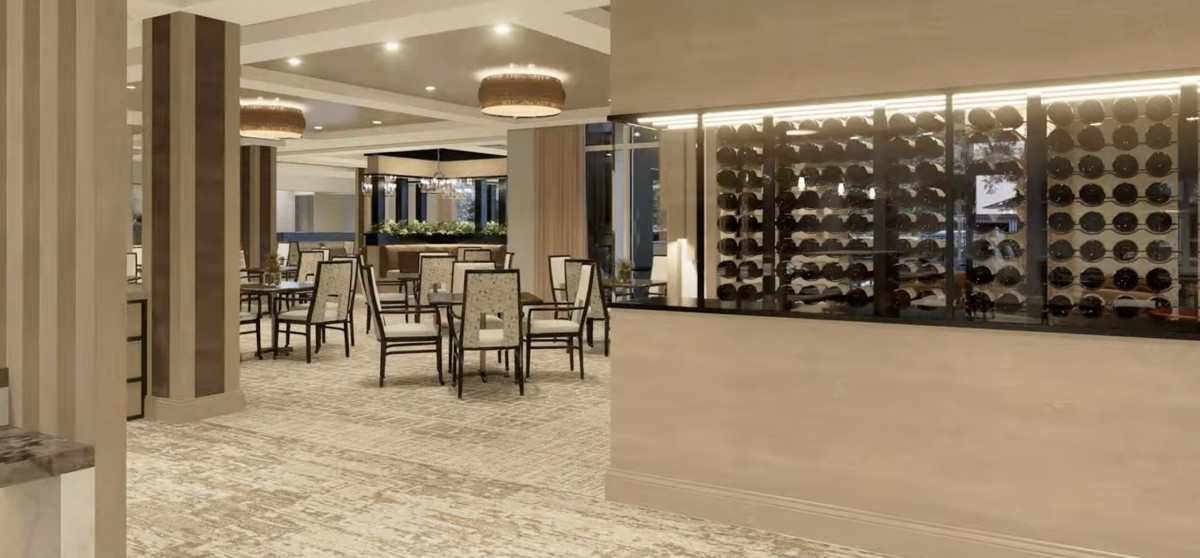 A modern restaurant interior featuring a dining area with stylish tables and chairs, complemented by a wine display.