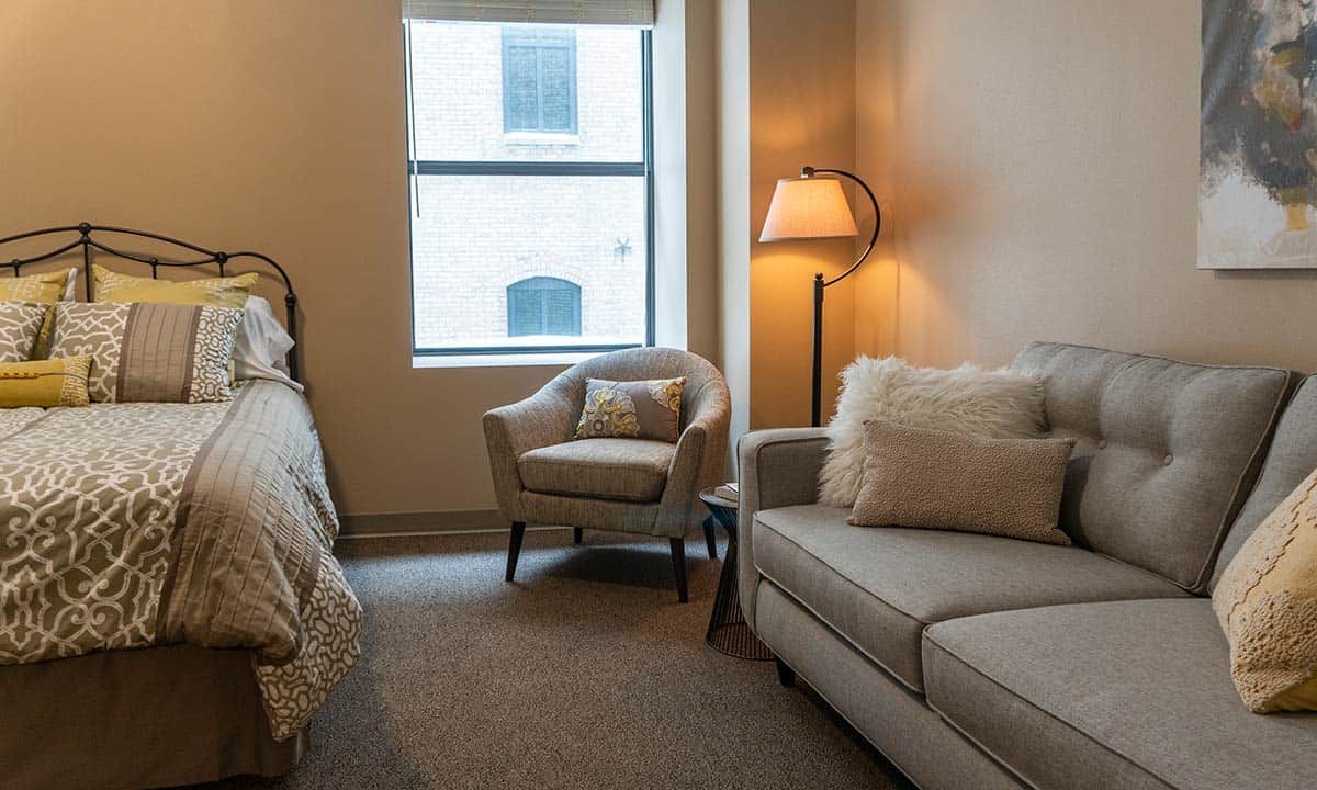 A cozy bedroom with comfortable furniture and soft lighting.