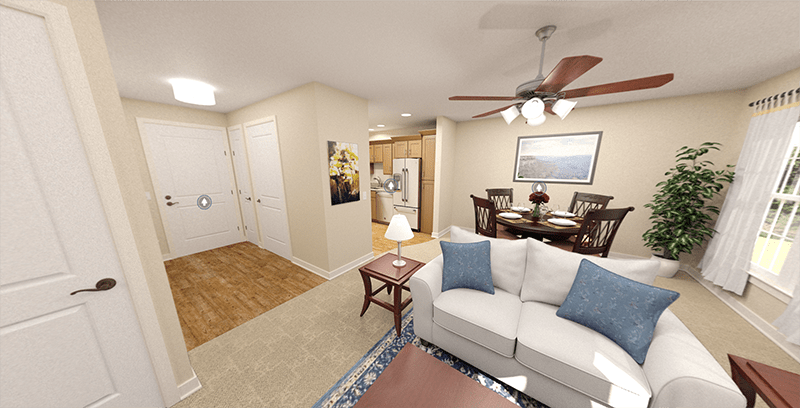 A cozy living room with an adjoining dining area and kitchen, featuring a ceiling fan and comfortable seating.