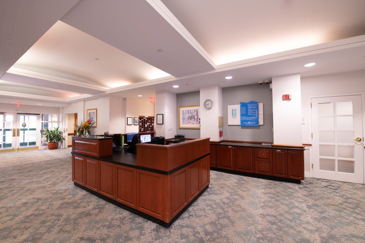 Interior view of a lobby with a reception desk and artwork on the walls.