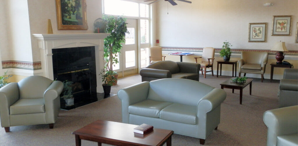 A cozy living room with sofas, a fireplace, and natural light.