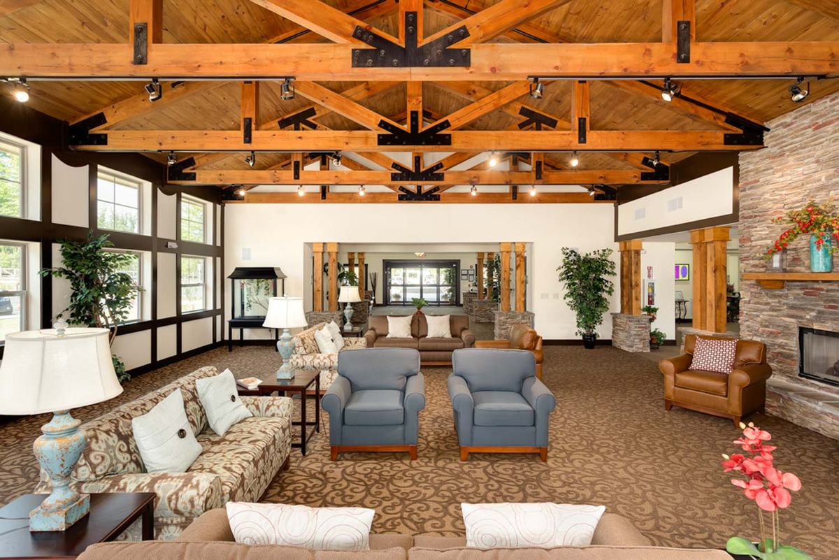 A spacious living room with comfortable seating and exposed wooden beams.