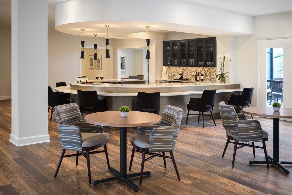 A modern kitchen with a dining area featuring a sleek bar and stylish seating.