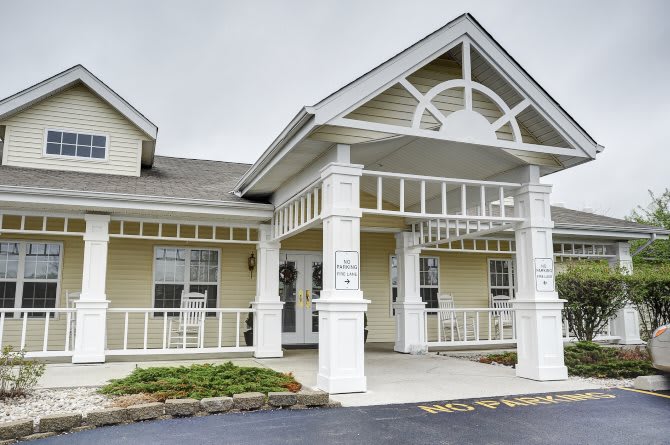 A residential building with a covered entrance and decorative columns.