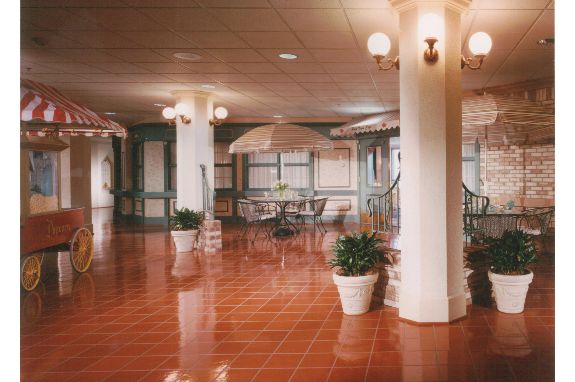 Spacious lobby interior with seating and decorative plants.