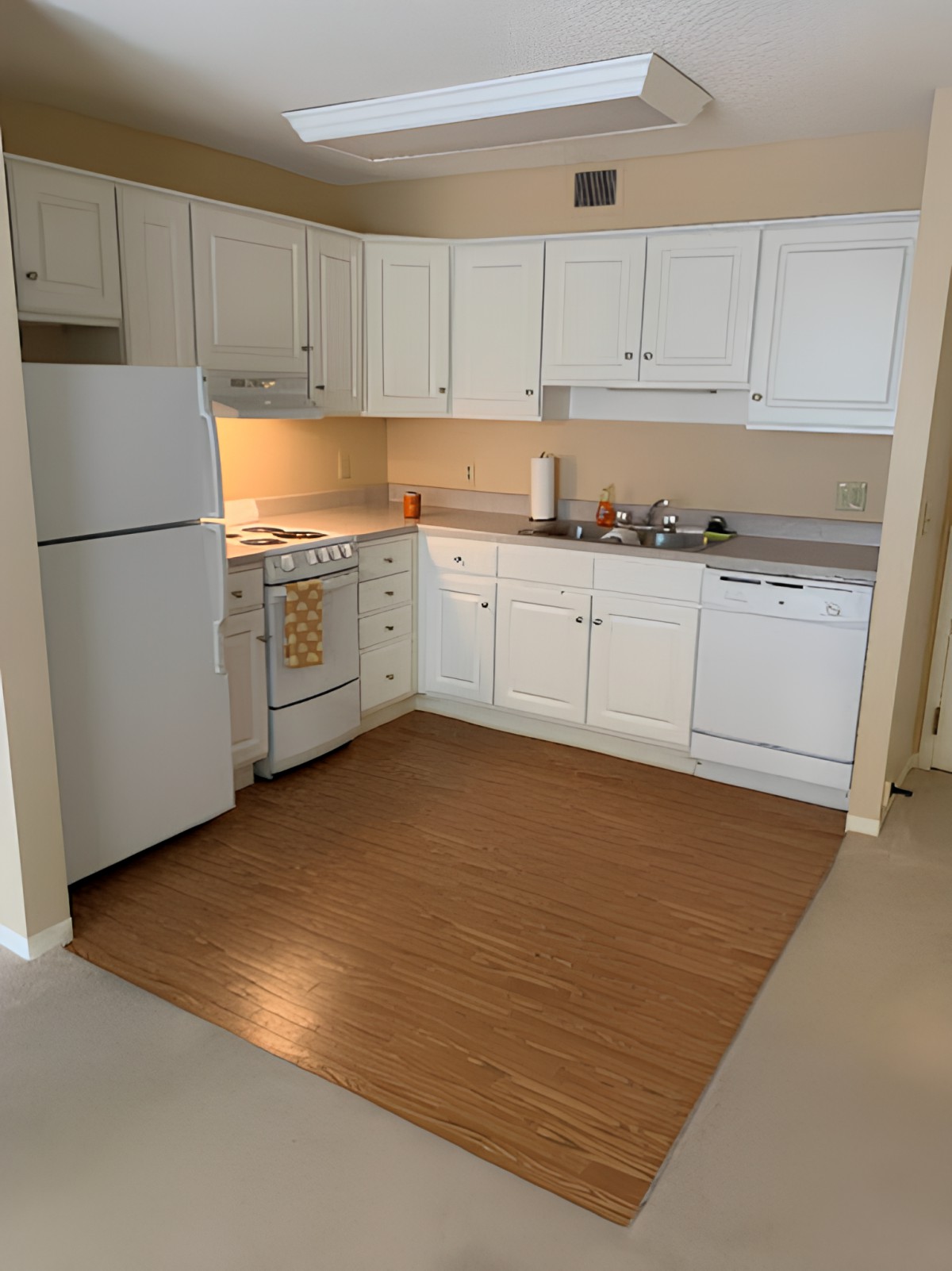 A kitchen with white cabinets, a refrigerator, stove, oven, and dishwasher.