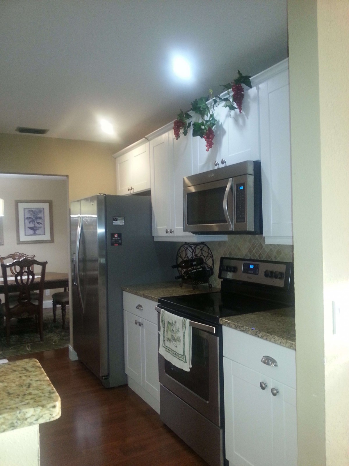 A modern kitchen with stainless steel appliances and a view into the dining area.