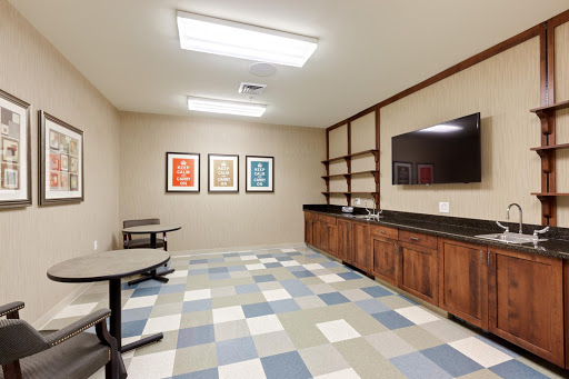 A modern office space featuring a flat-screen TV, shelves, and framed artwork on the walls.