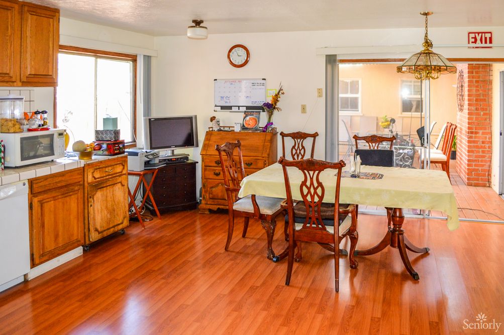 A cozy dining room with wooden flooring and classic furniture.