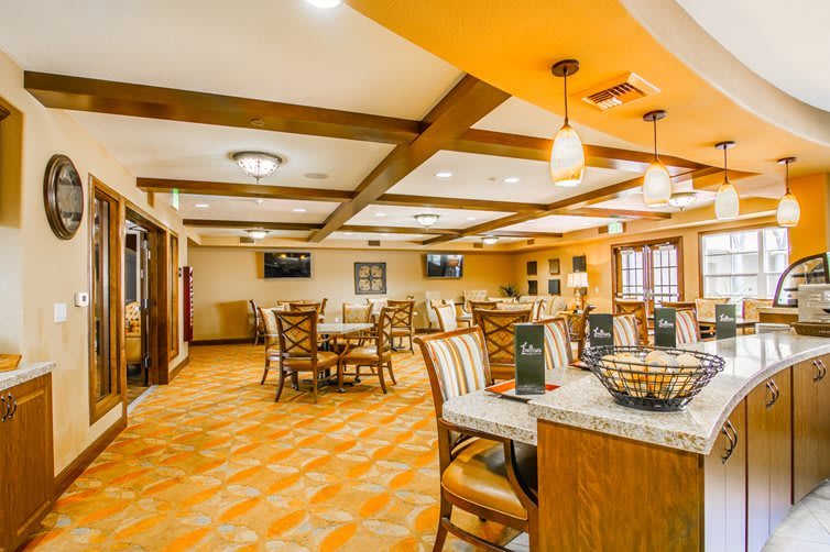 A cozy dining area with warm lighting and neatly arranged tables and chairs.