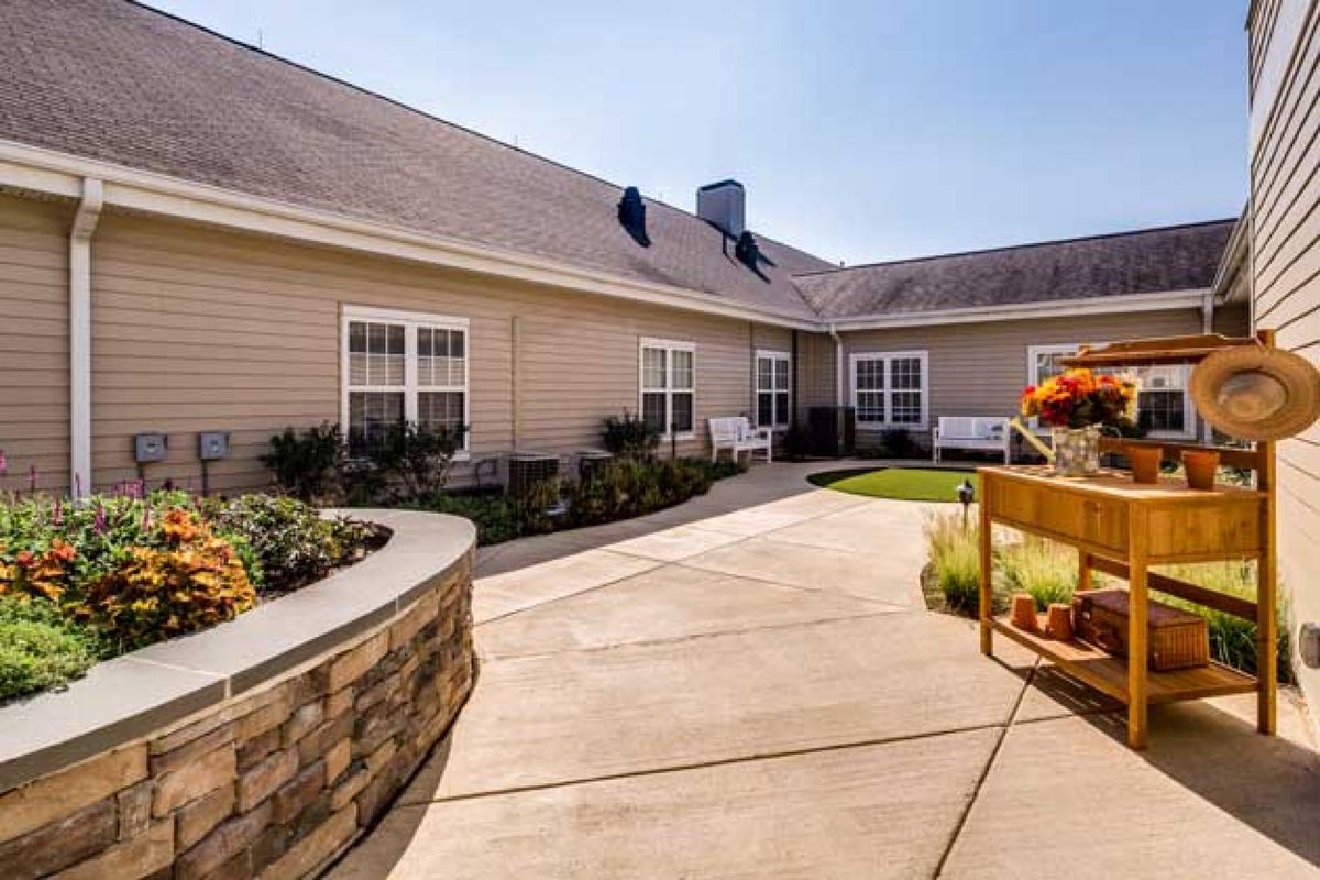 A charming courtyard with a patio area surrounded by a landscaped garden.