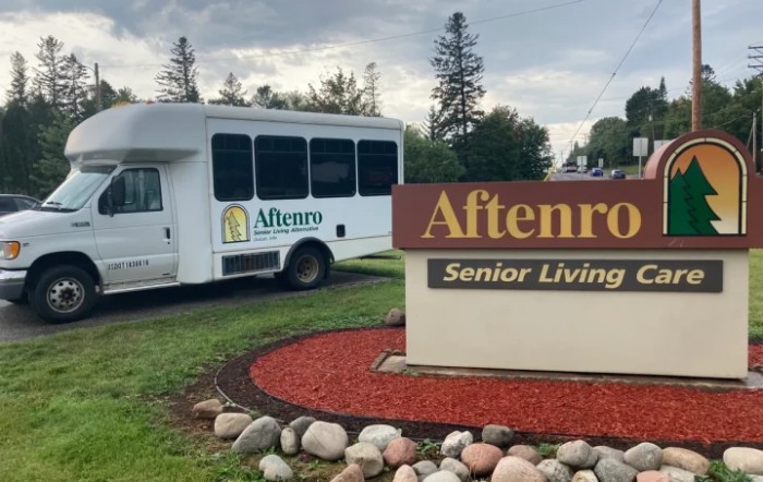 A bus parked next to the Aftenro Senior Living sign.