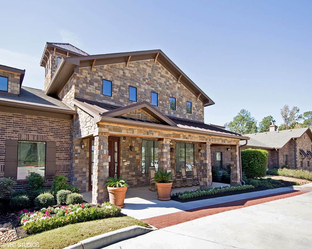 A suburban brick house with well-maintained landscaping.