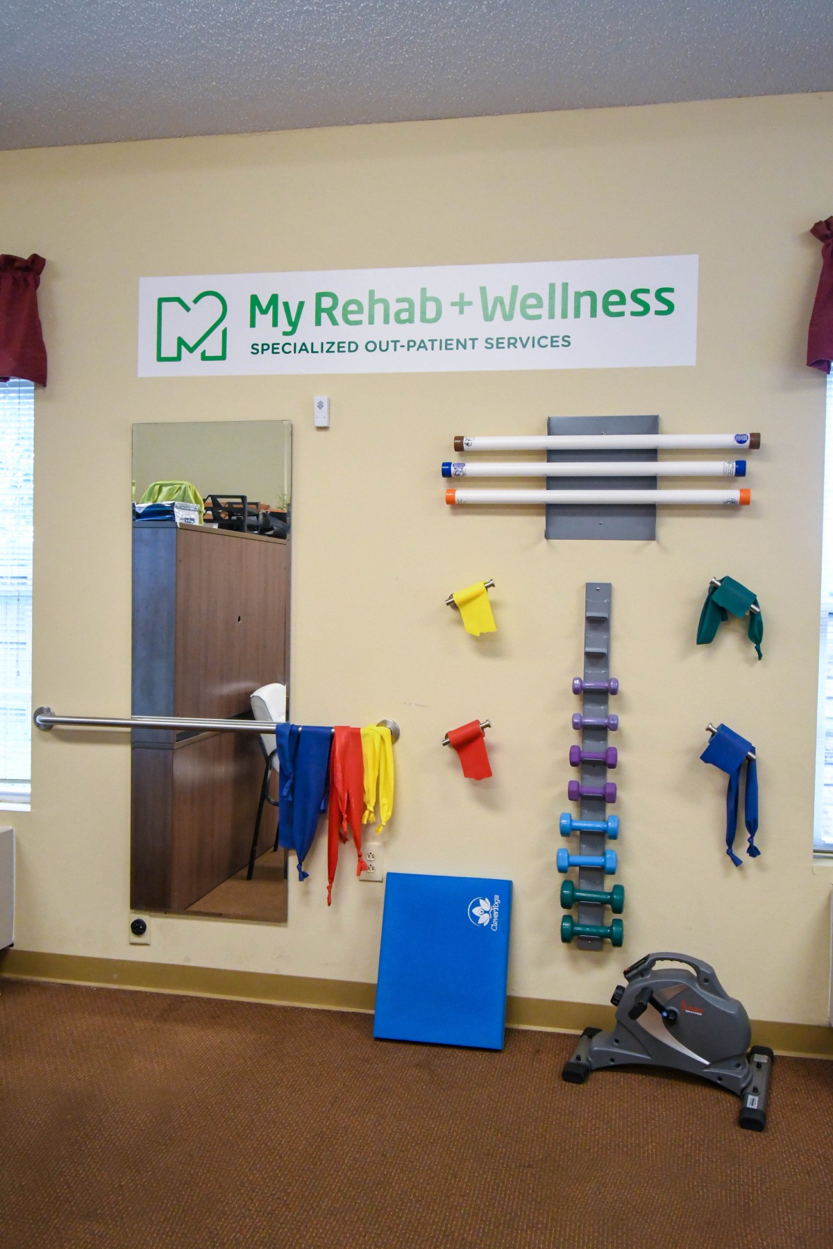 A rehab and wellness center featuring various physical therapy equipment and exercise bands.