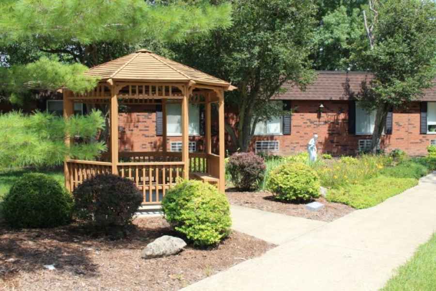 A quaint gazebo surrounded by well-maintained landscaping in a garden setting.