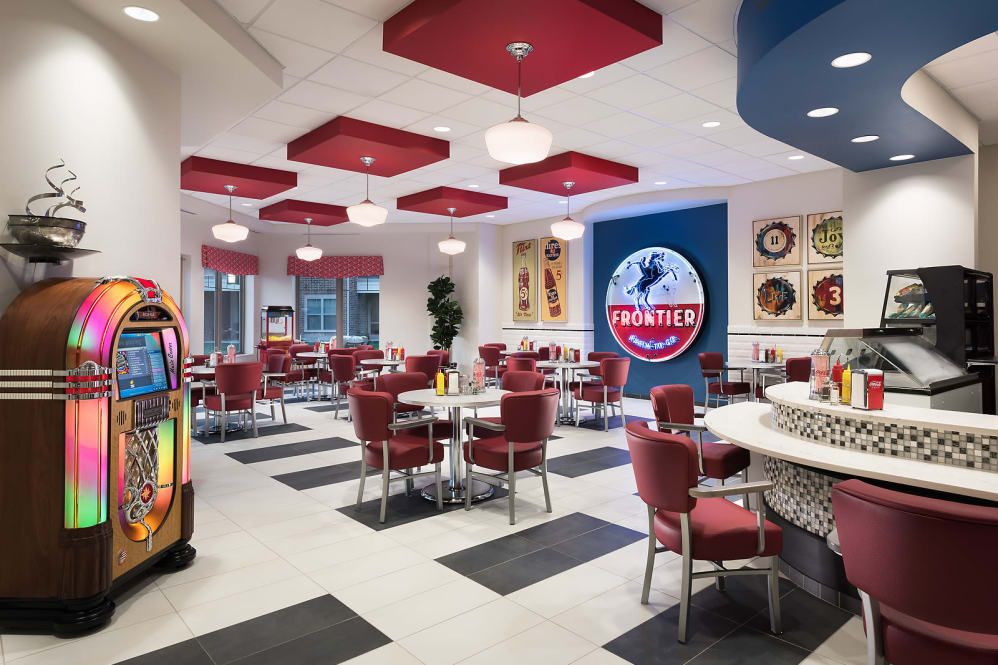A retro-themed diner interior with red seating and a jukebox.