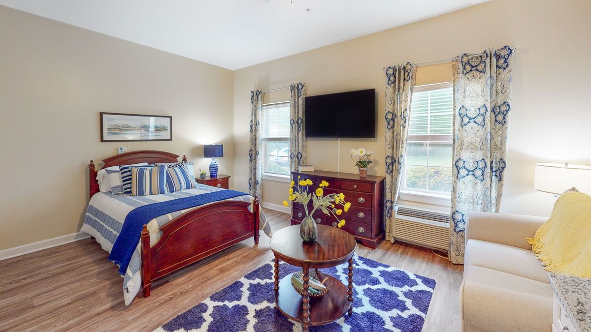 A cozy bedroom with elegant furnishings and natural light streaming in through the windows.