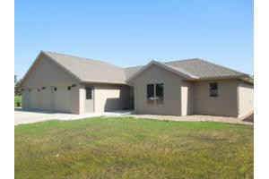 A single-story suburban house with a manicured lawn.