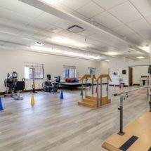 An indoor gym with various exercise equipment and open space for workouts.