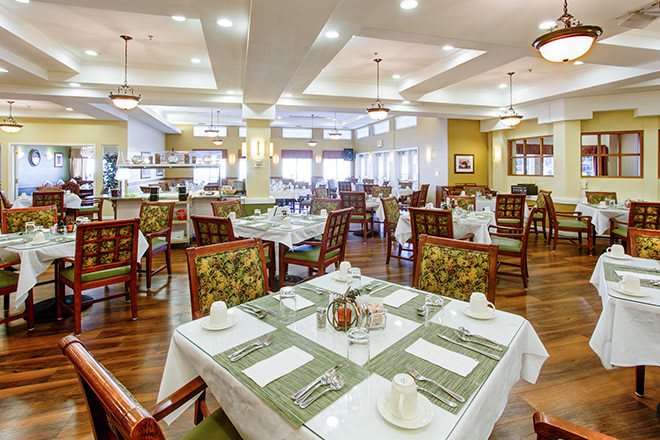 A spacious and elegantly decorated restaurant dining area with neatly arranged tables and chairs.