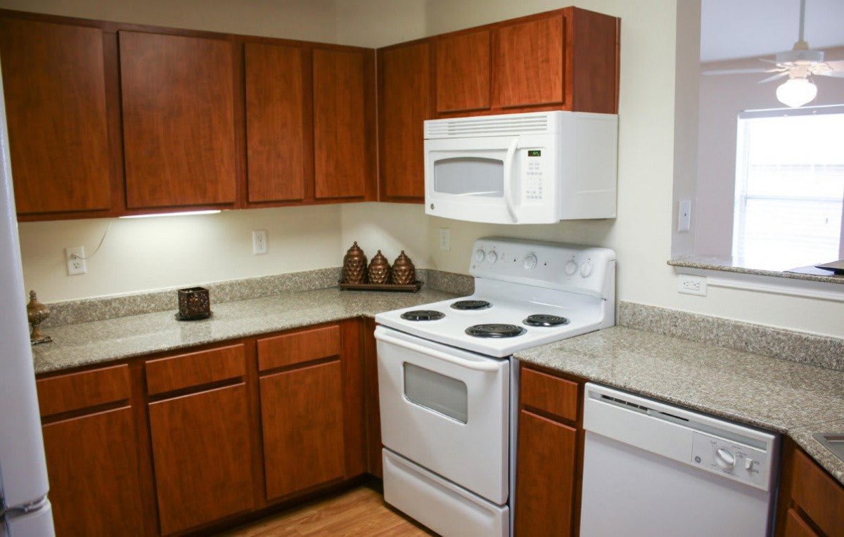A modern kitchen with wooden cabinets and white appliances.